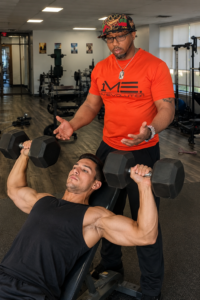 elson teaching a man to lift weights in both hands