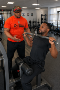 elson teaching a man to use weight machine